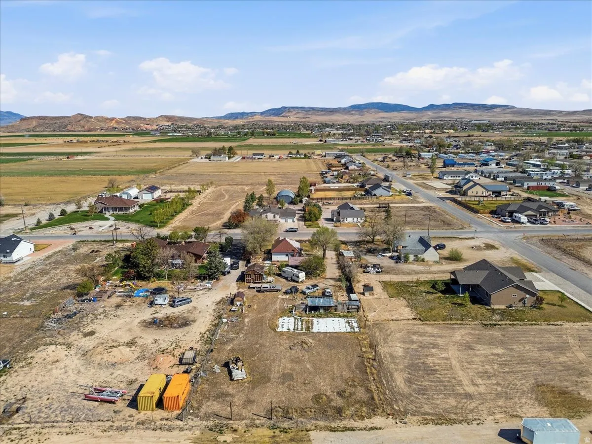 Aerial view of property and surrounding area with a mountain backdrop, nearby suburban area, and rural landscape