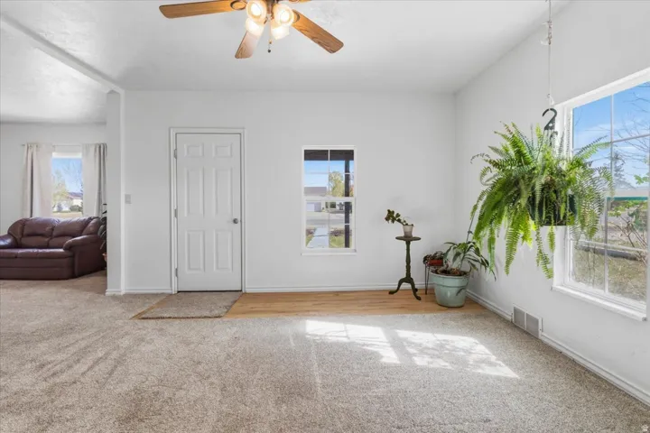 Entryway featuring light carpet and a ceiling fan