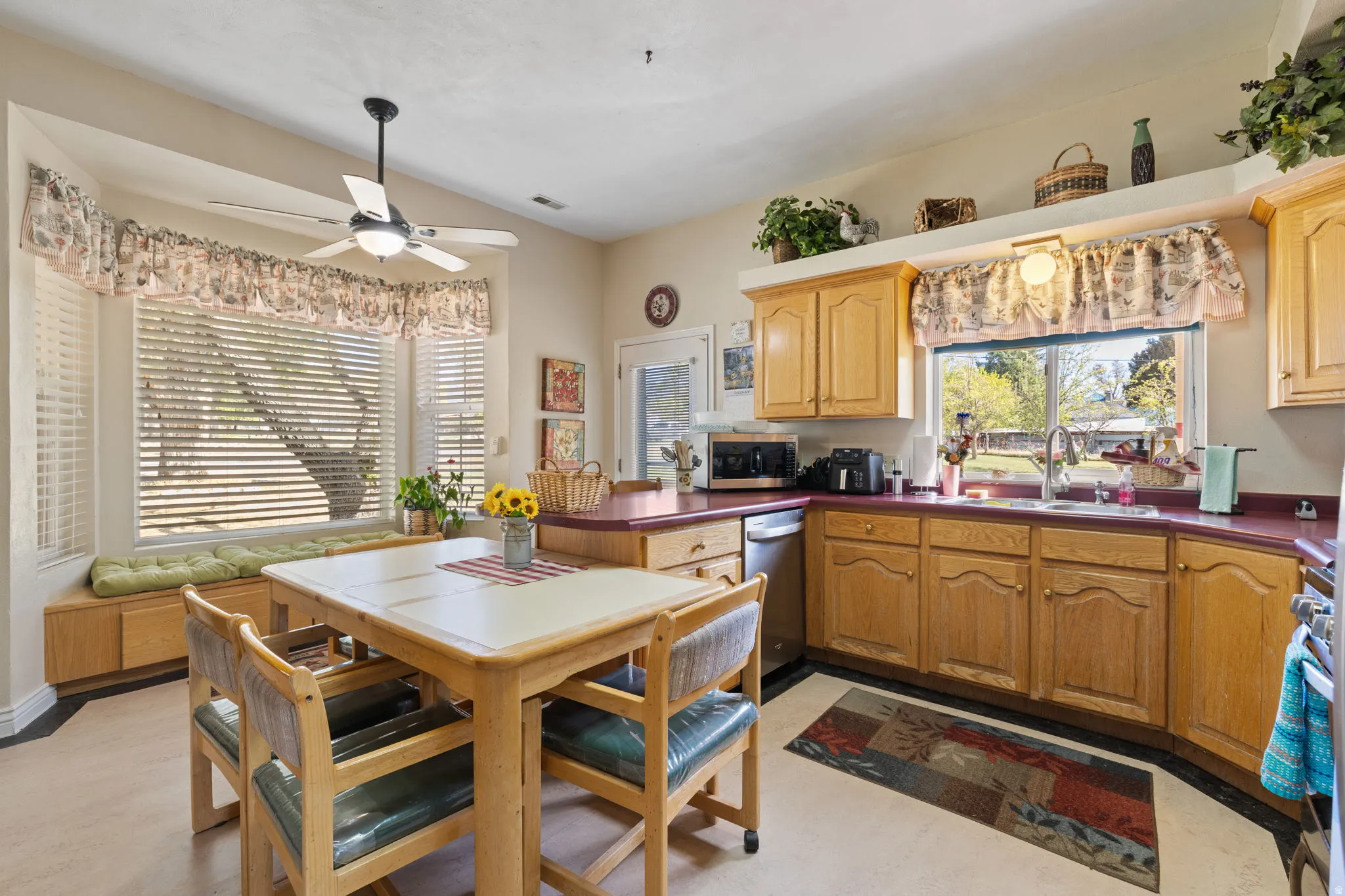 Country style kitchen with stainless steel appliances, accent brick wall and ample lighting