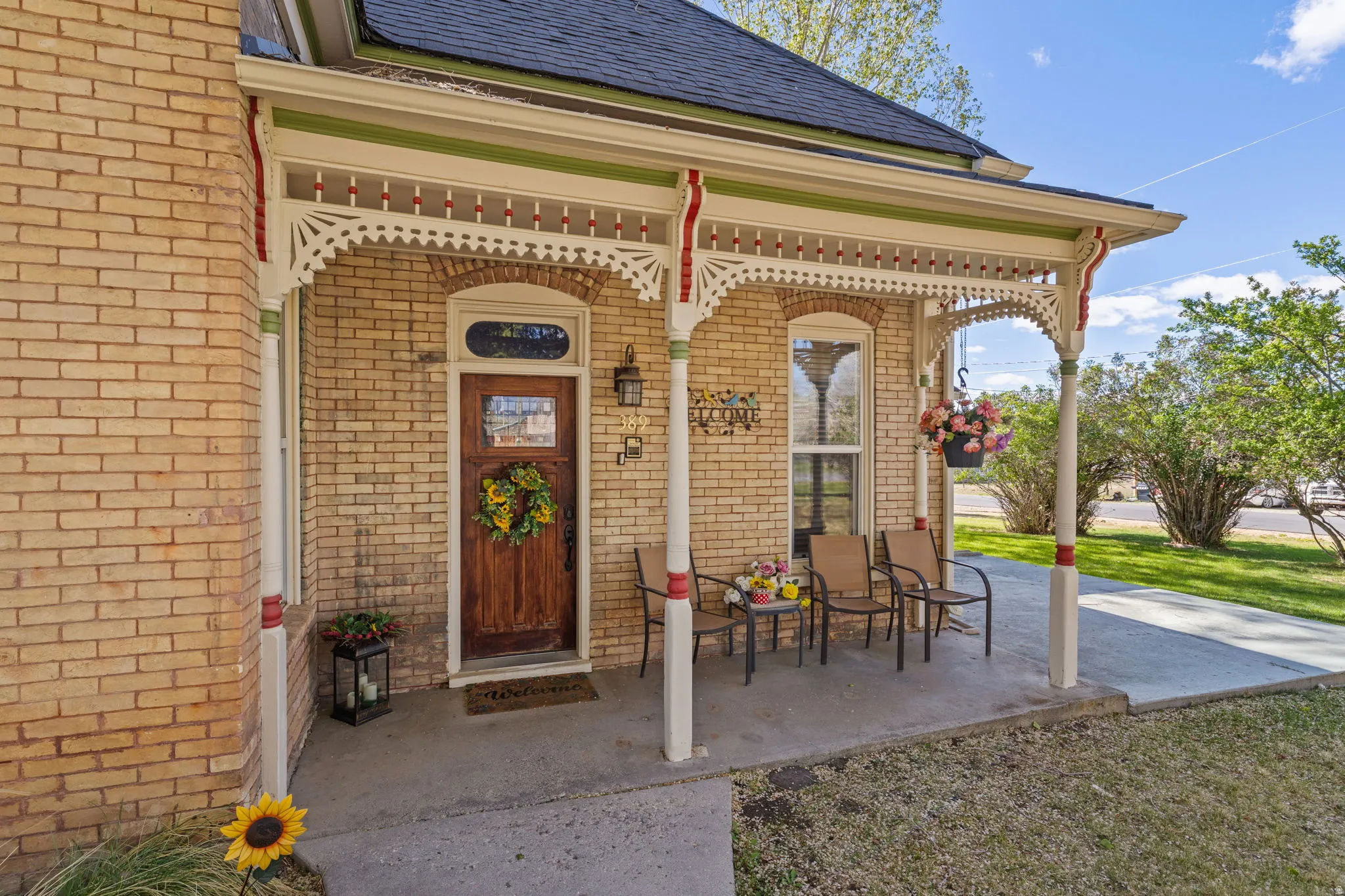 Entrance to property with brick siding, covered porch, and roof with shingles