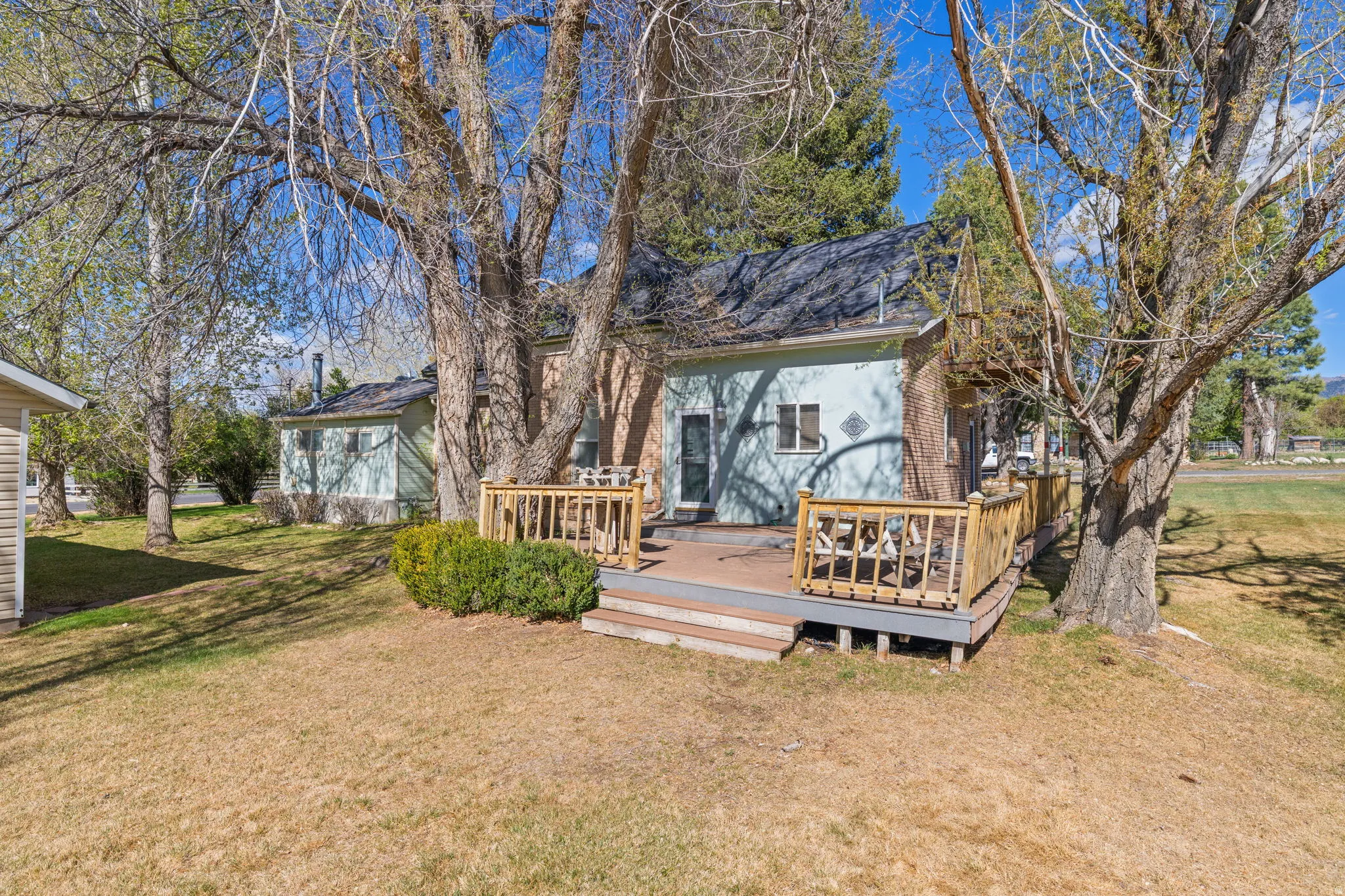 Rear view of property featuring a lawn and a wooden deck
