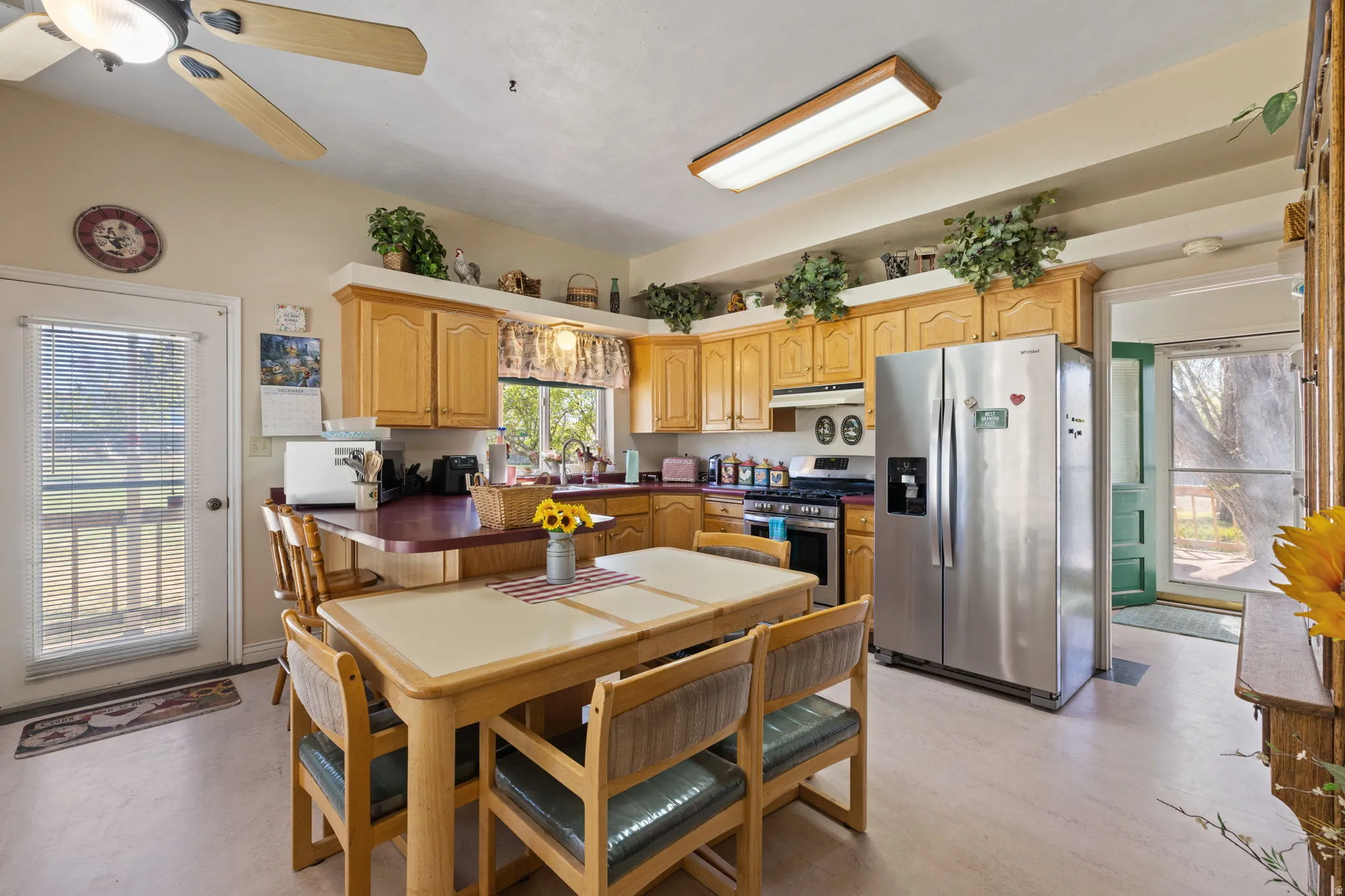 Country style kitchen with stainless steel appliances, accent brick wall and ample lighting