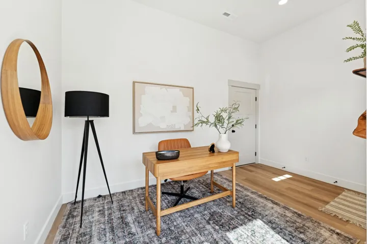 Office with wood finished floors and recessed lighting