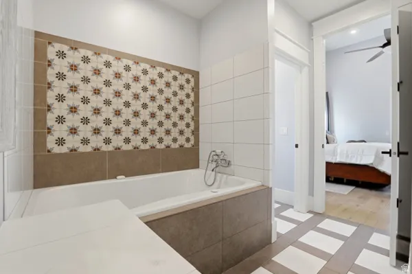 Ensuite bathroom with a bath, ceiling fan, and light tile patterned flooring