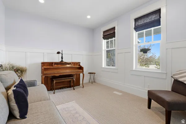 Sitting room featuring a decorative wall, a wainscoted wall, carpet floors, and recessed lighting