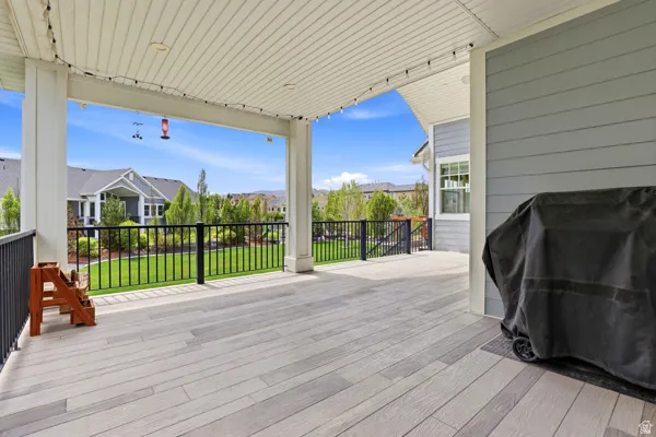 Deck with grilling area, a lawn, and a residential view