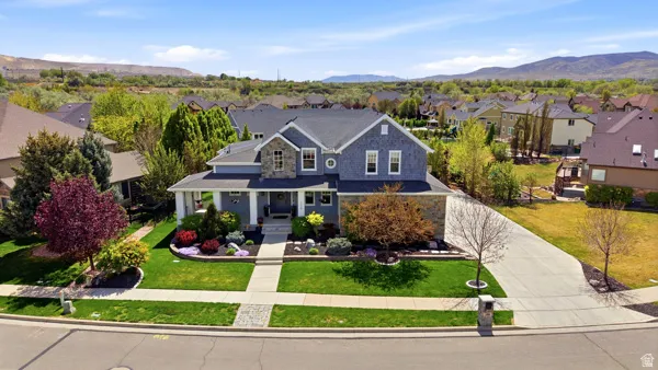 View of front of property featuring covered porch, a residential view, a mountain view, and a front yard