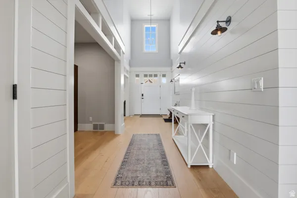 Entryway with a high ceiling and light wood-style floors