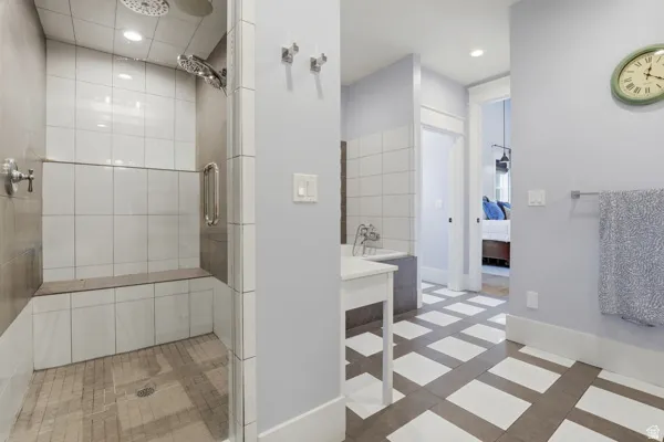 Ensuite bathroom with a shower stall, recessed lighting, and vanity