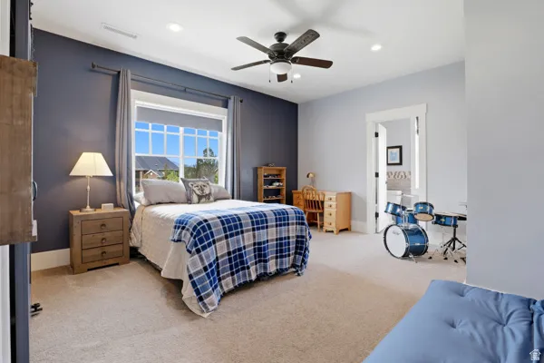 Bedroom featuring light carpet, recessed lighting, ceiling fan, and connected bathroom