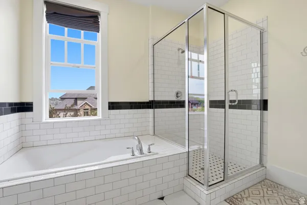 Bathroom featuring a bath, a shower stall, plenty of natural light, and tile patterned floors