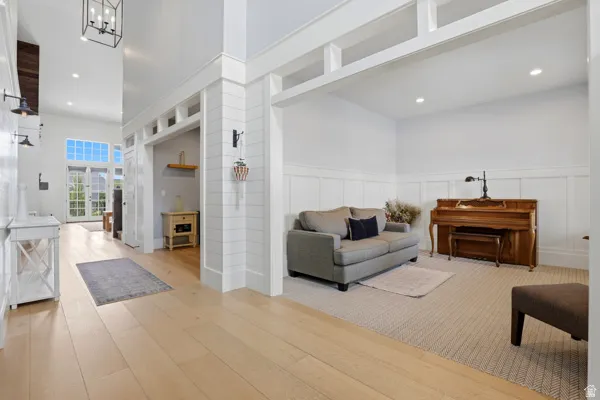 Living area with recessed lighting, a decorative wall, a wainscoted wall, and light wood finished floors