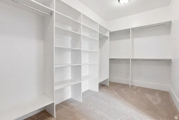 Walk in closet with light carpet