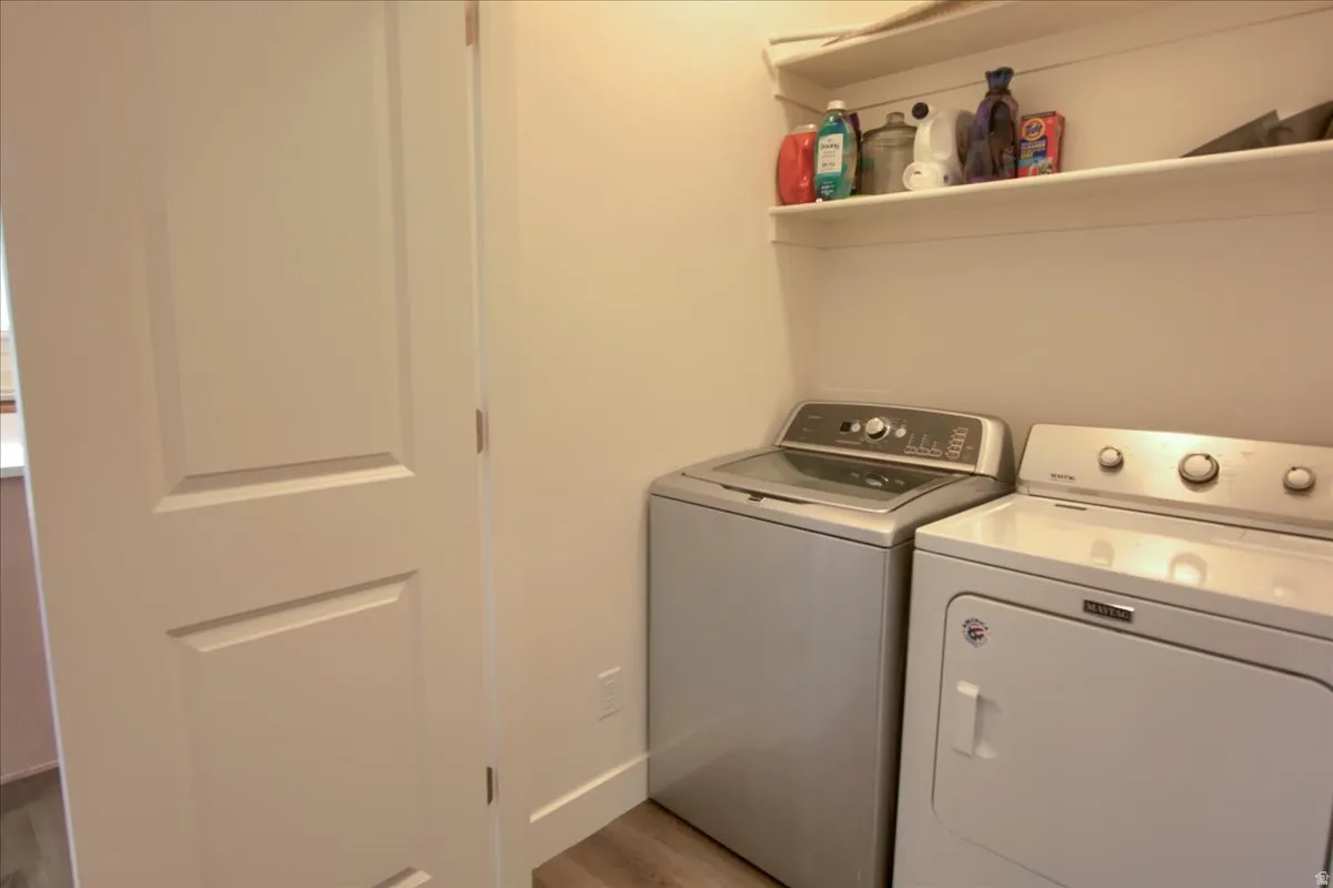 Laundry area featuring washer and dryer and light wood-type flooring