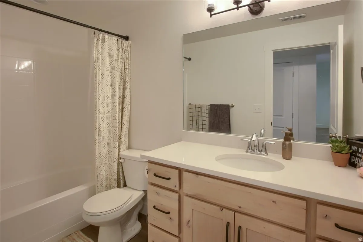 Full bath featuring vanity and shower / bath combination with curtain
