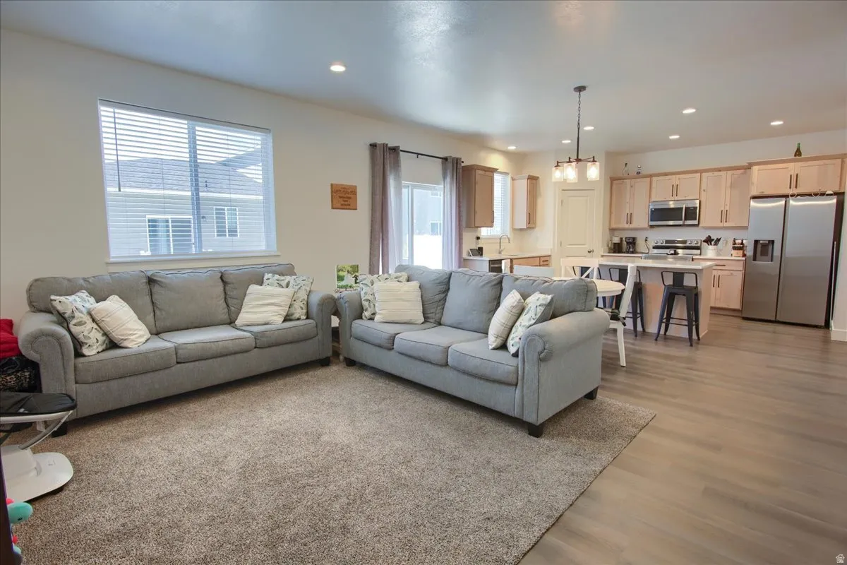 Living room featuring light wood-type flooring and a chandelier