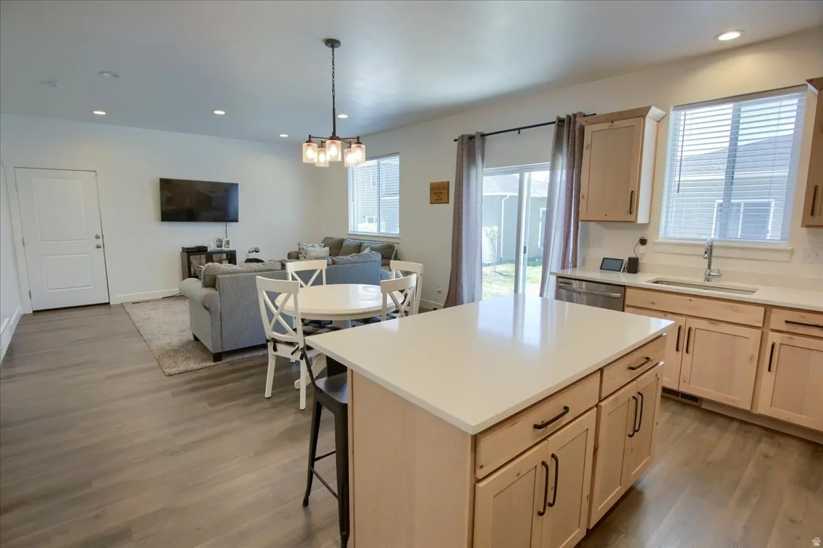Kitchen featuring light wood finish cabinetry, open floor plan, a kitchen breakfast bar, light wood finished floors, and a kitchen island