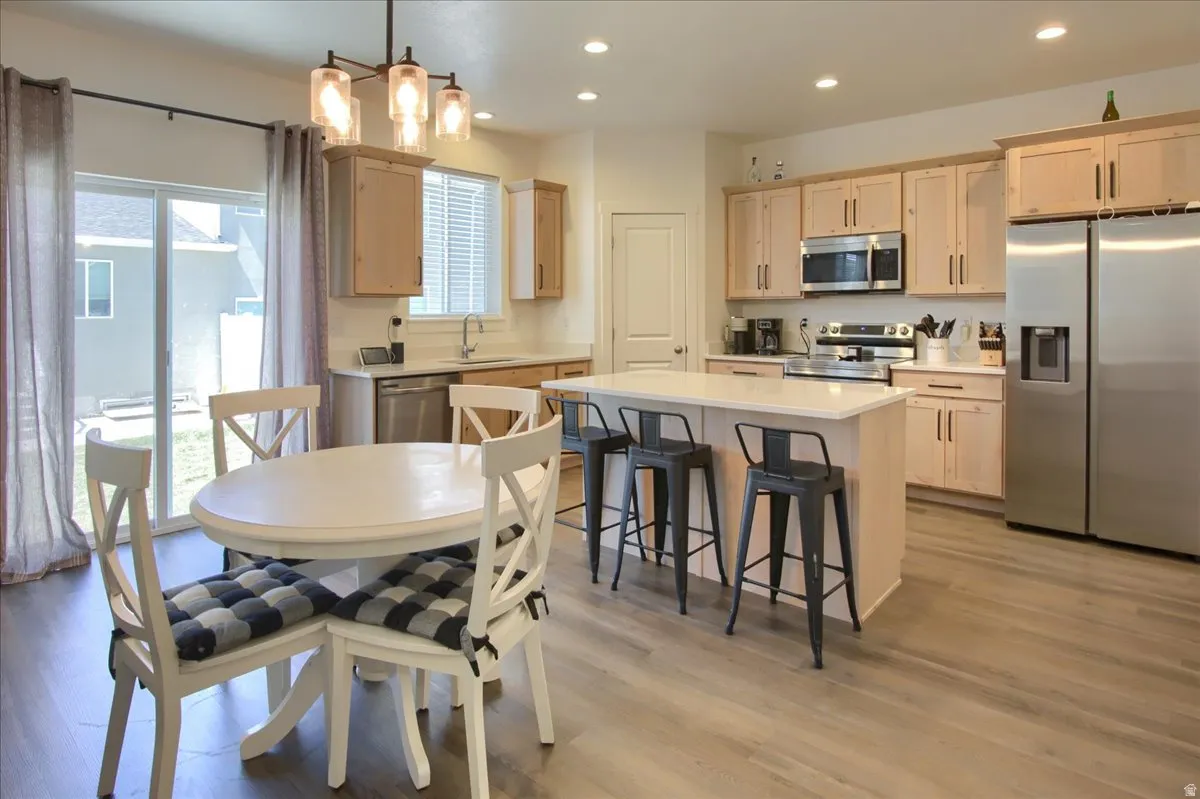 Kitchen with stainless steel appliances, light wood finish cabinets, and light wood-type flooring