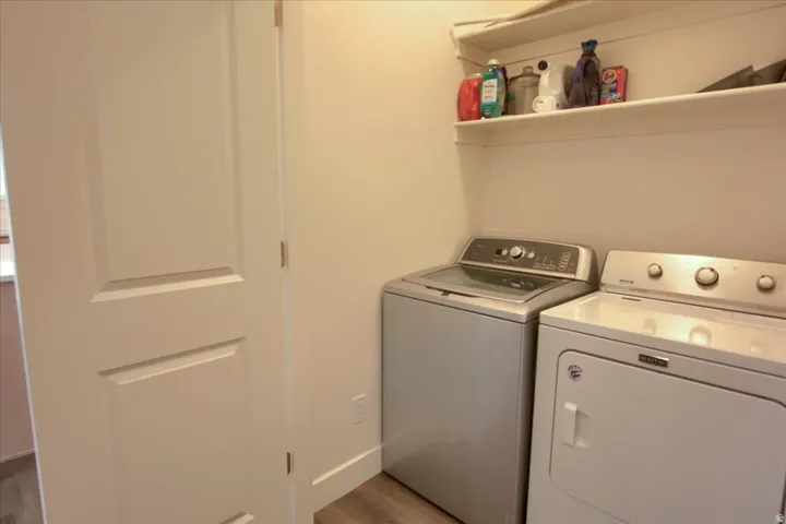Laundry area featuring washer and dryer and light wood-type flooring