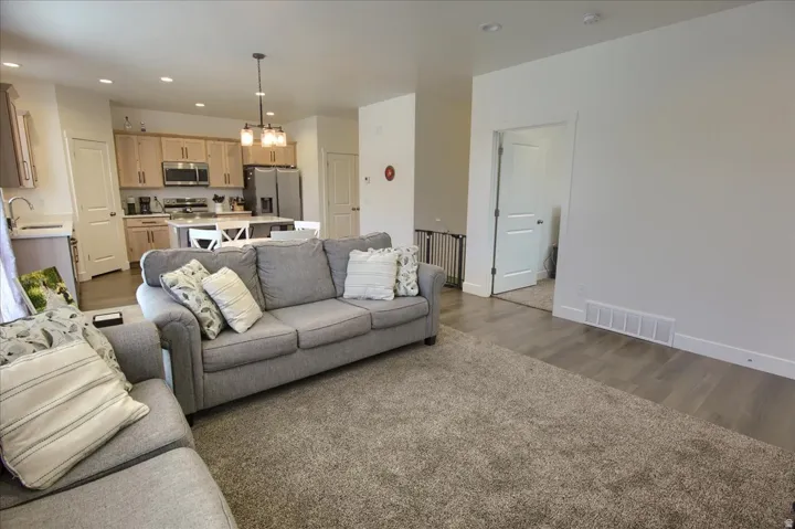 Living room featuring hanging lights and dark wood-style flooring