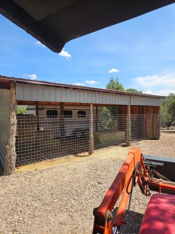 Attached covered structure with a metal roof and corrugated metal siding