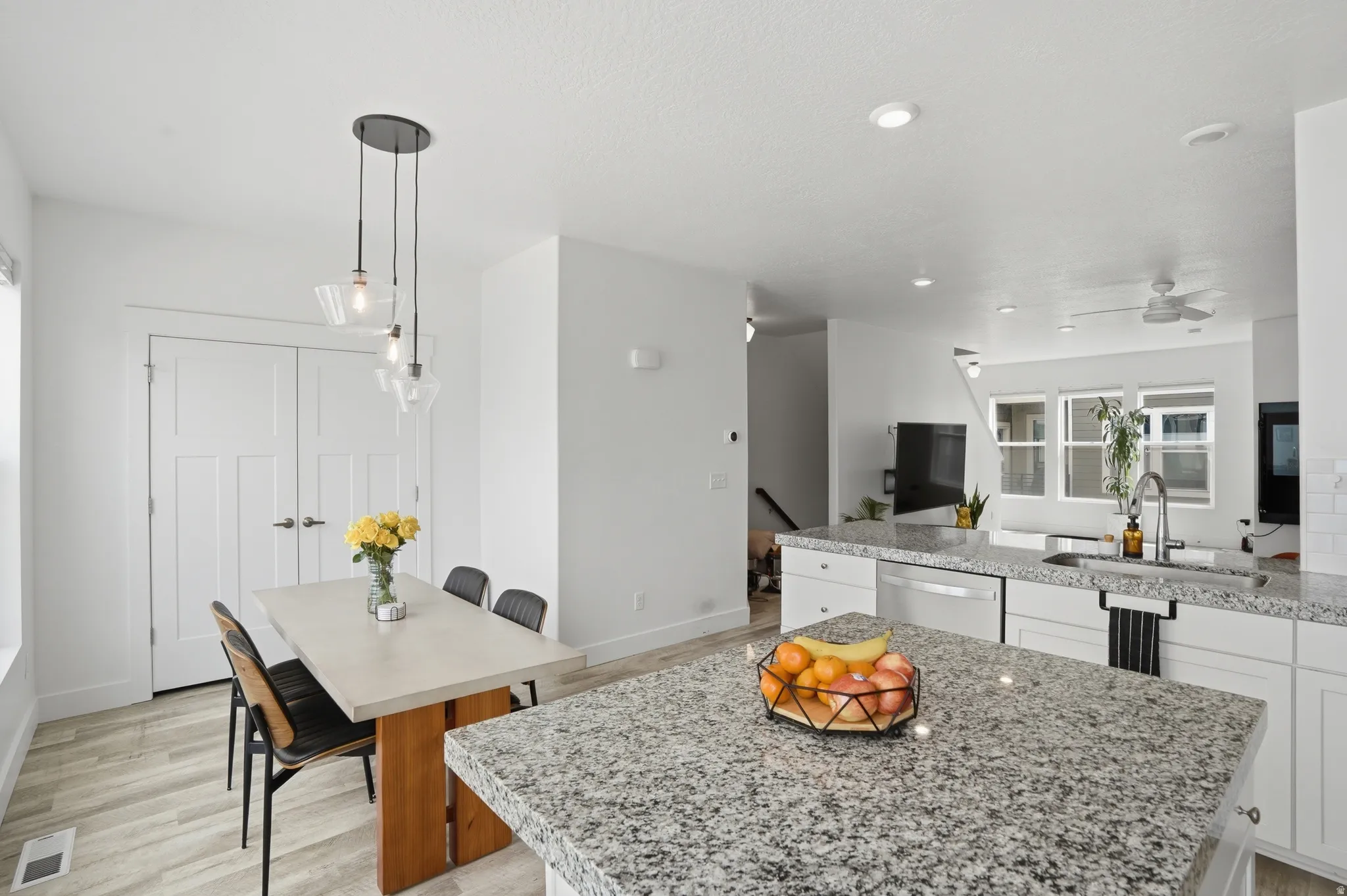 Kitchen with white cabinets, light stone counters, a peninsula, and a kitchen island
