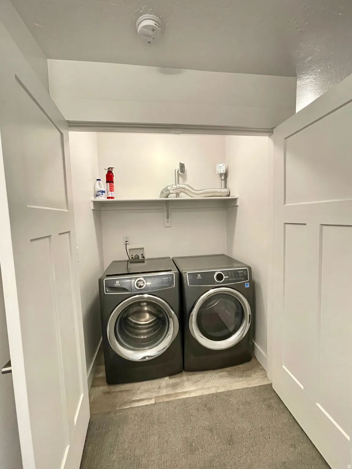 Laundry area with washer and dryer and light carpet