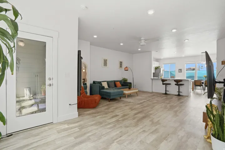 Living area with light wood finished floors, ceiling fan, and recessed lighting