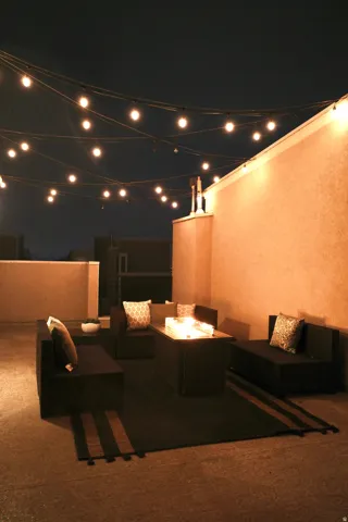 Patio at night with a patio area and an outdoor living space with a fire pit