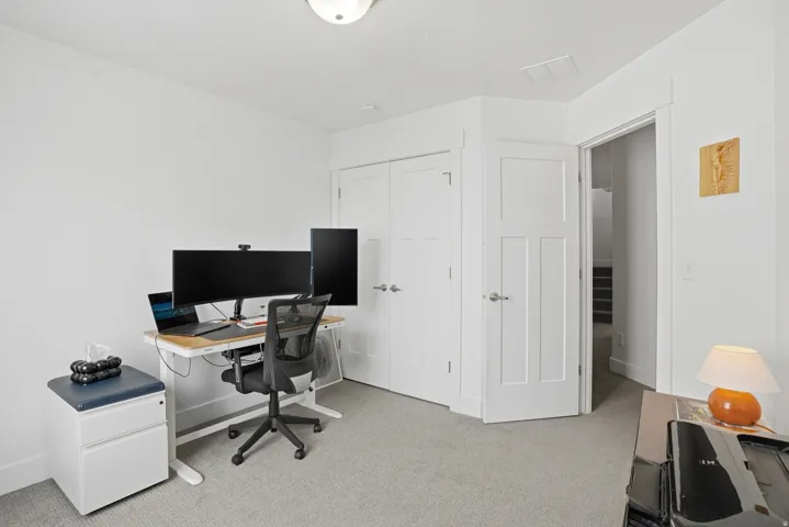 Office space with light colored carpet and baseboards