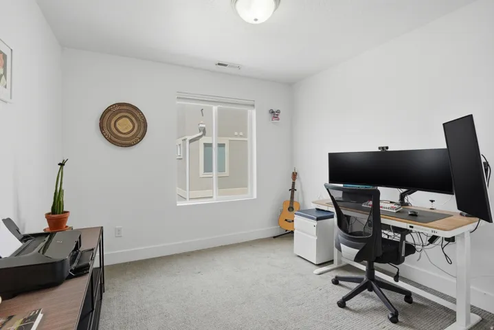 Office area featuring light colored carpet and baseboards