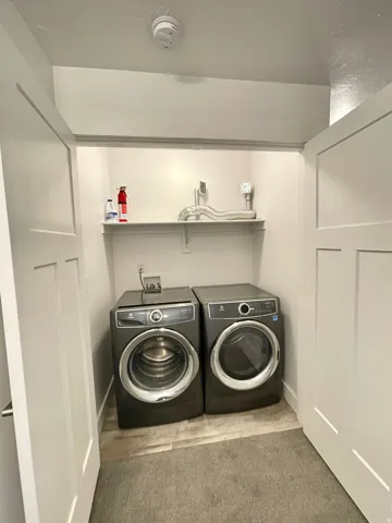 Laundry area with washer and dryer and light carpet