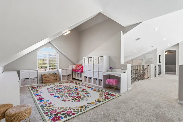 Playroom with carpet floors and lofted ceiling