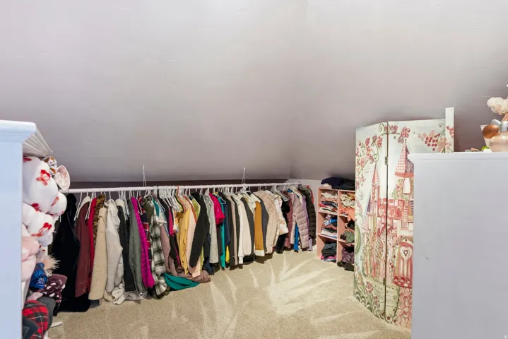 Walk in closet with carpet flooring and vaulted ceiling