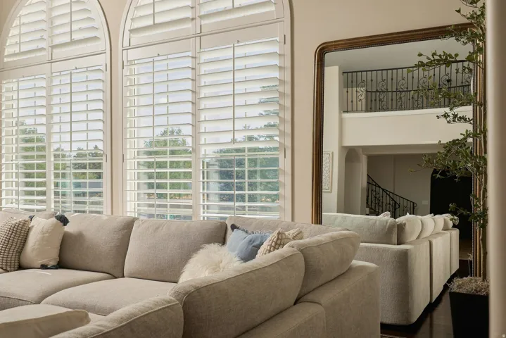 Arch-top windows with white plantation shutters