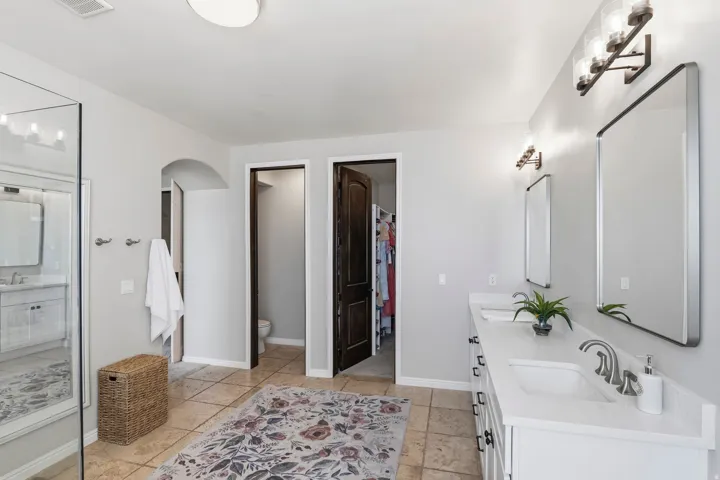 Bathroom with double vanity and a walk in closet