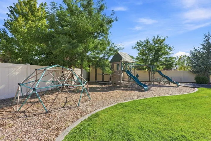 Dedicated play area featuring a geodesic dome climber, a playset with slides, and wood chip ground cover