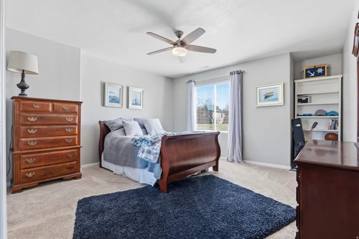 Bedroom featuring light carpet, ceiling fan, and a textured ceiling