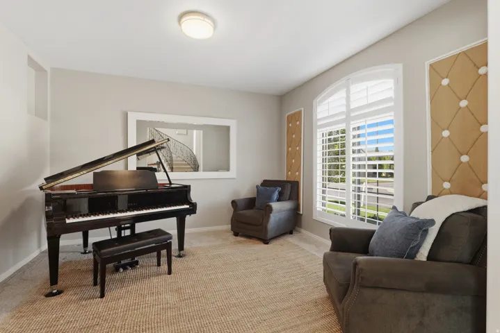 Arched window with plantation shutters, neutral wall tones, and recessed wall panels