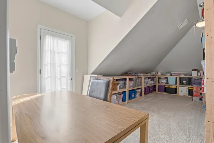 Office featuring light colored carpet and vaulted ceiling