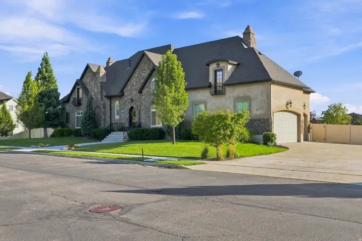 Stone and stucco exterior with multiple gables and a dormer