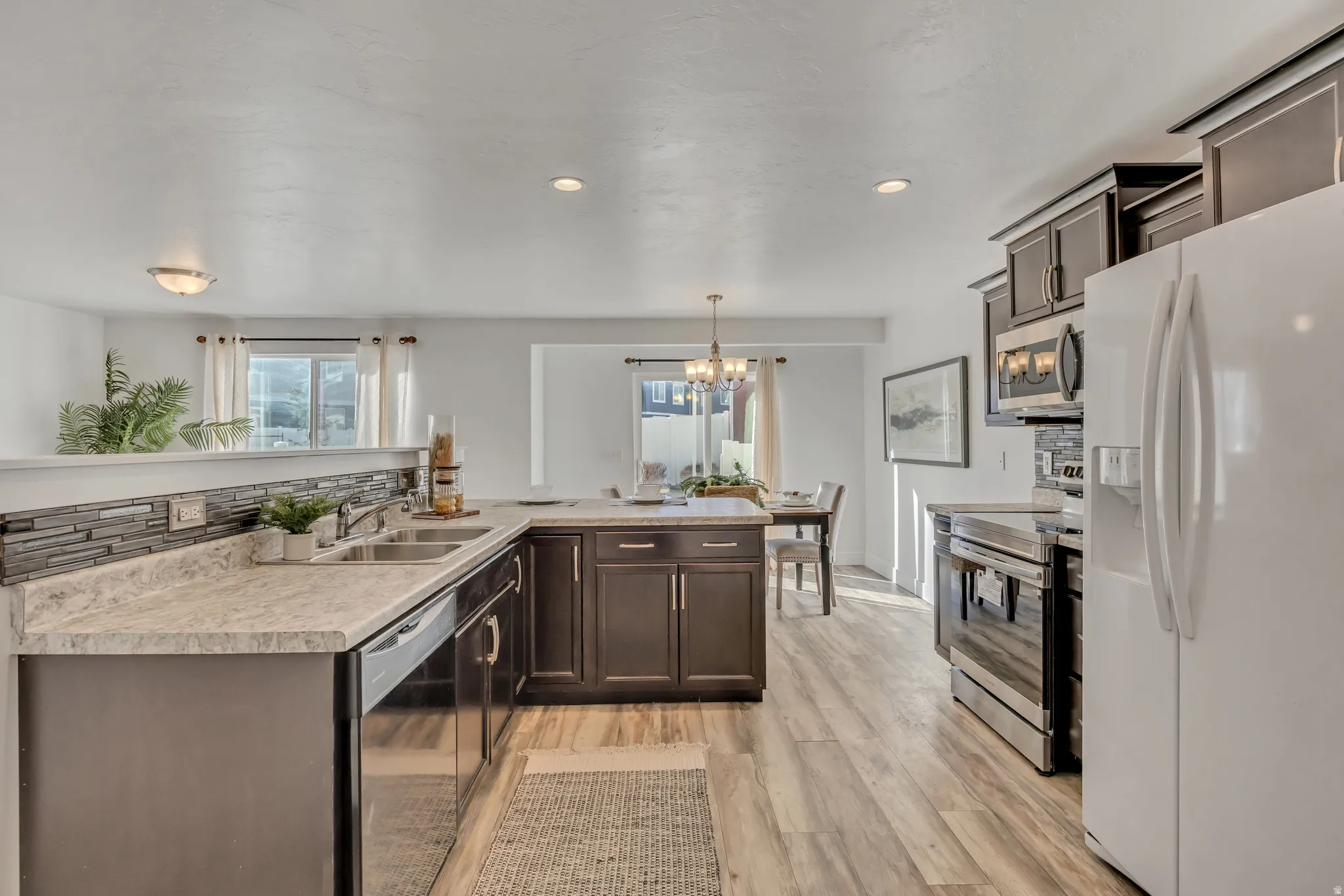 Kitchen featuring dark wood finish cabinets, stainless steel appliances, and light countertops