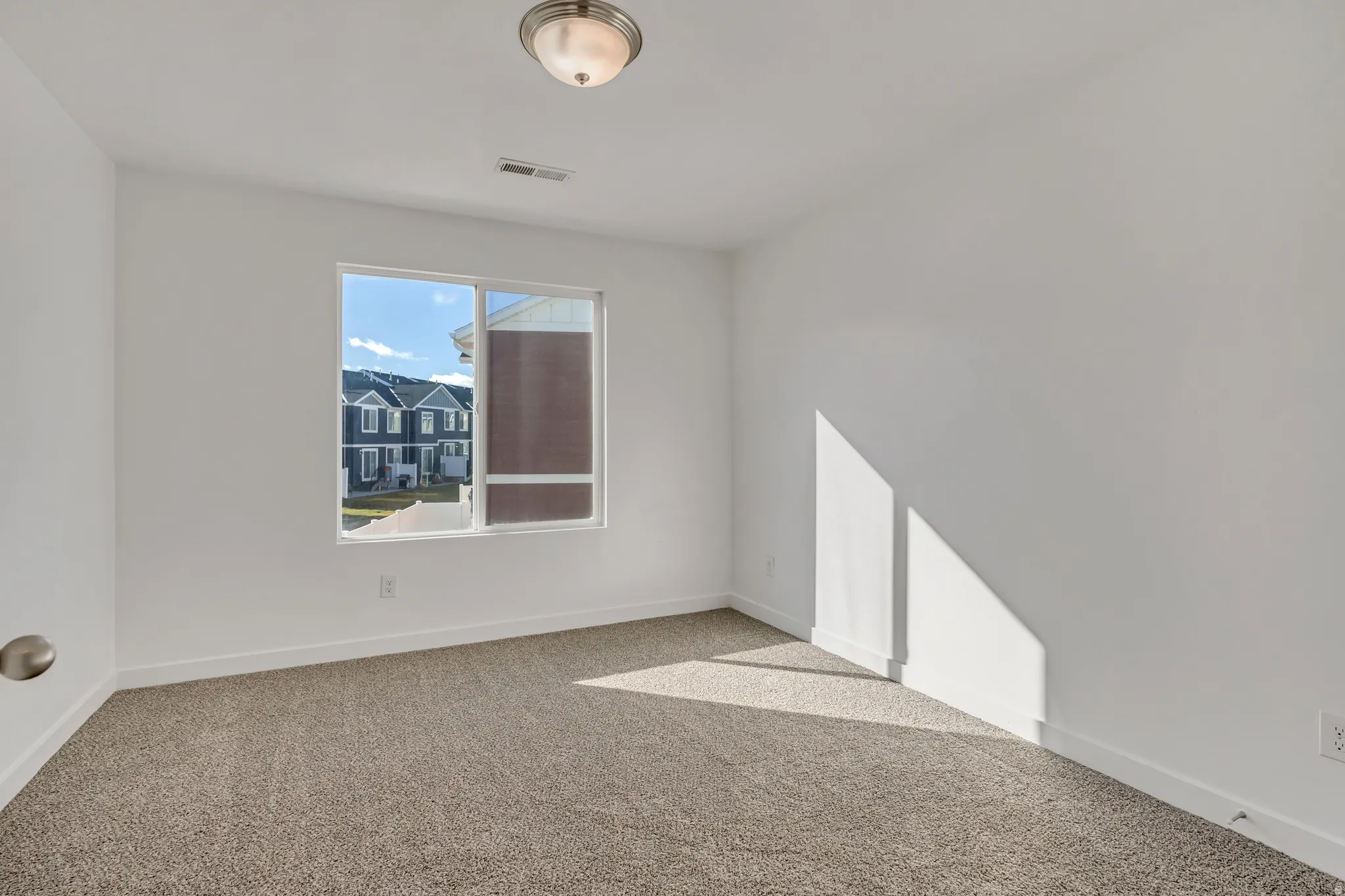 Unfurnished room with light colored carpet and baseboards
