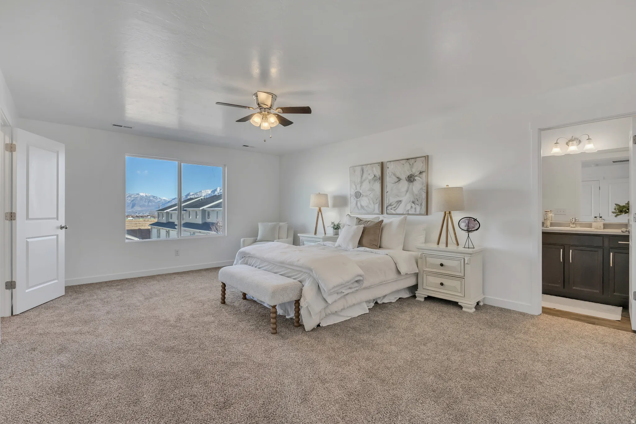 Bedroom featuring light colored carpet, a mountain view, ceiling fan, and ensuite bath