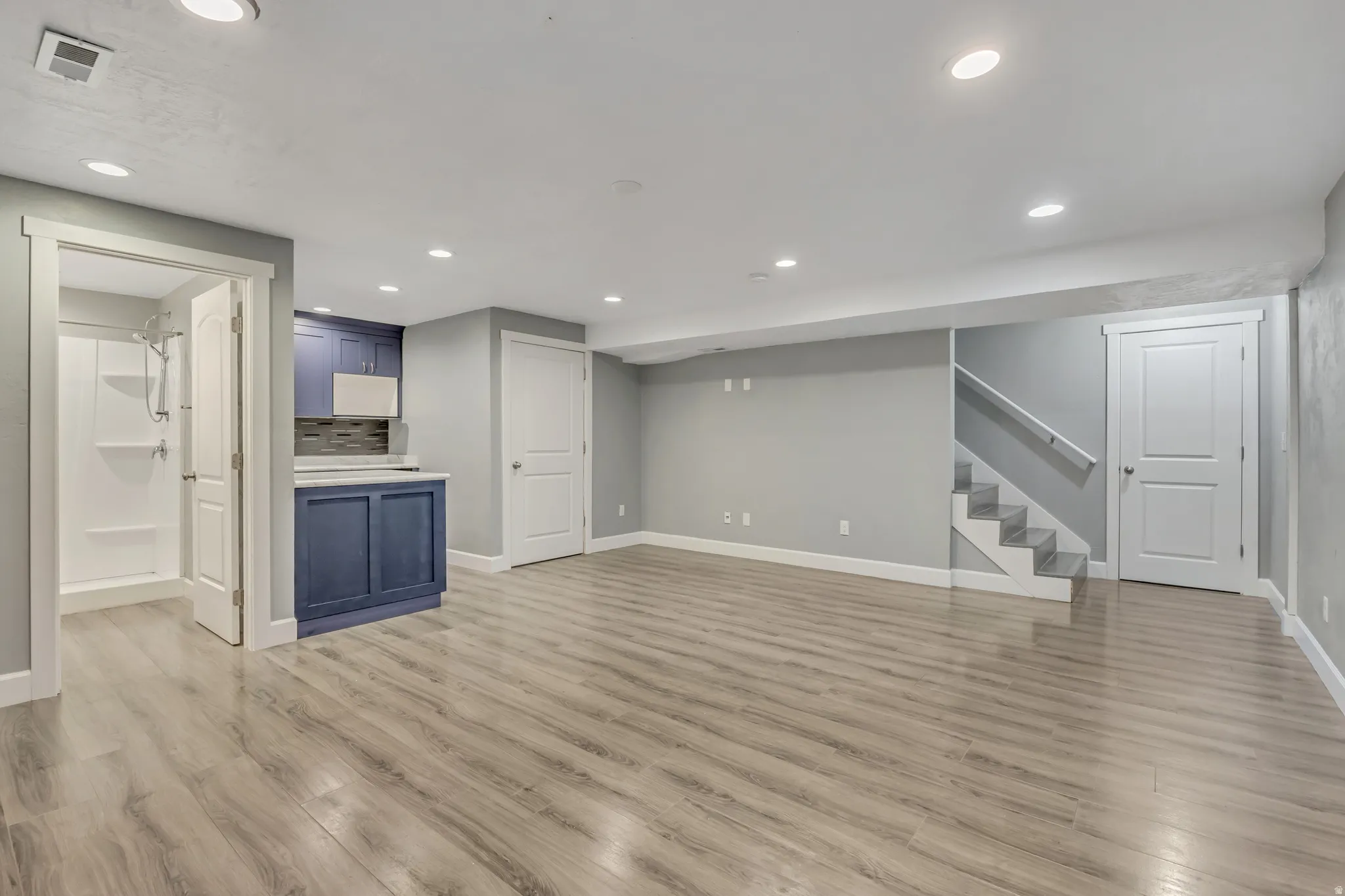 Finished basement featuring light wood finished floors and recessed lighting