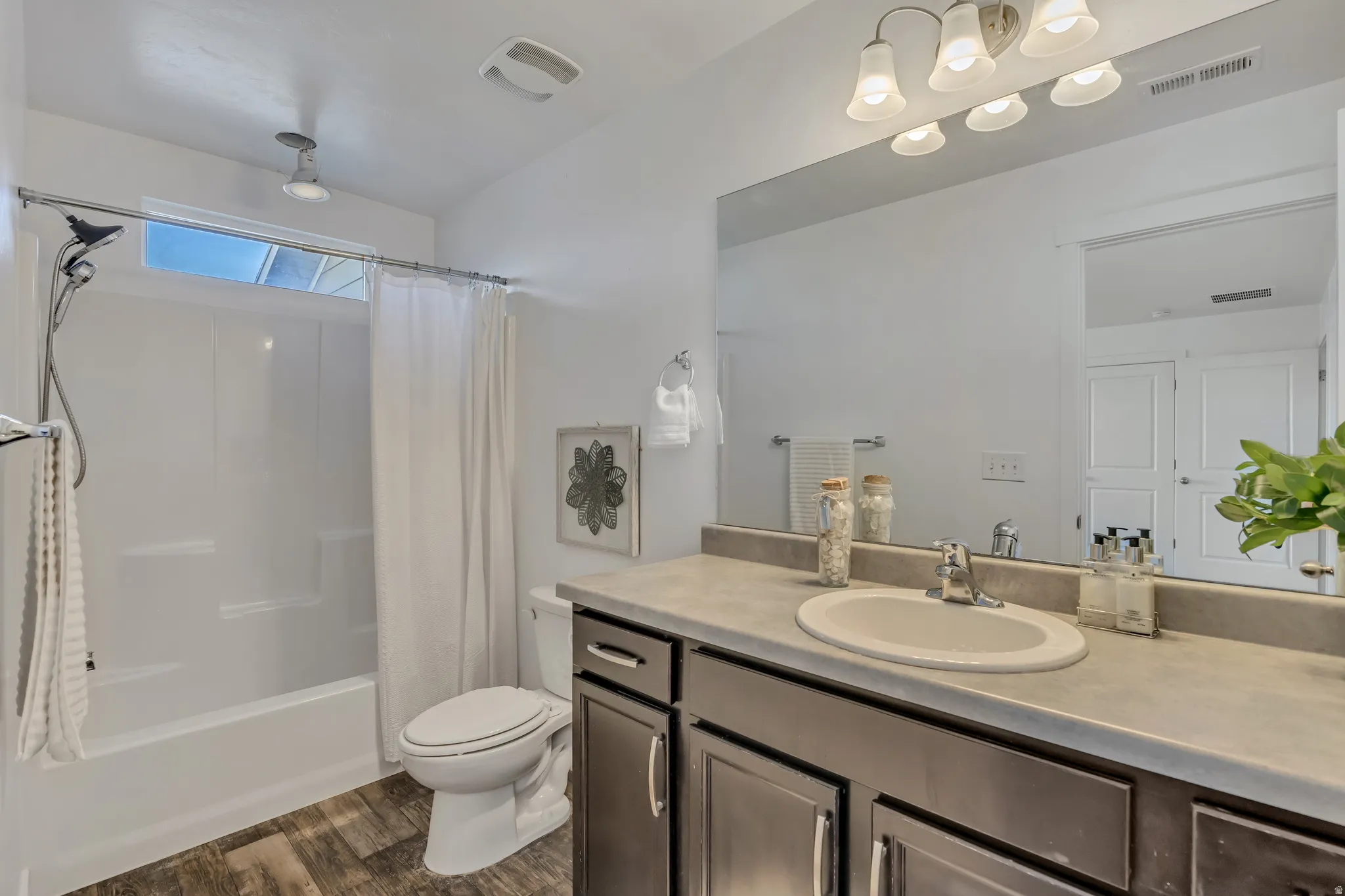 Full bathroom with vanity, dark wood-type flooring, and shower / tub combo