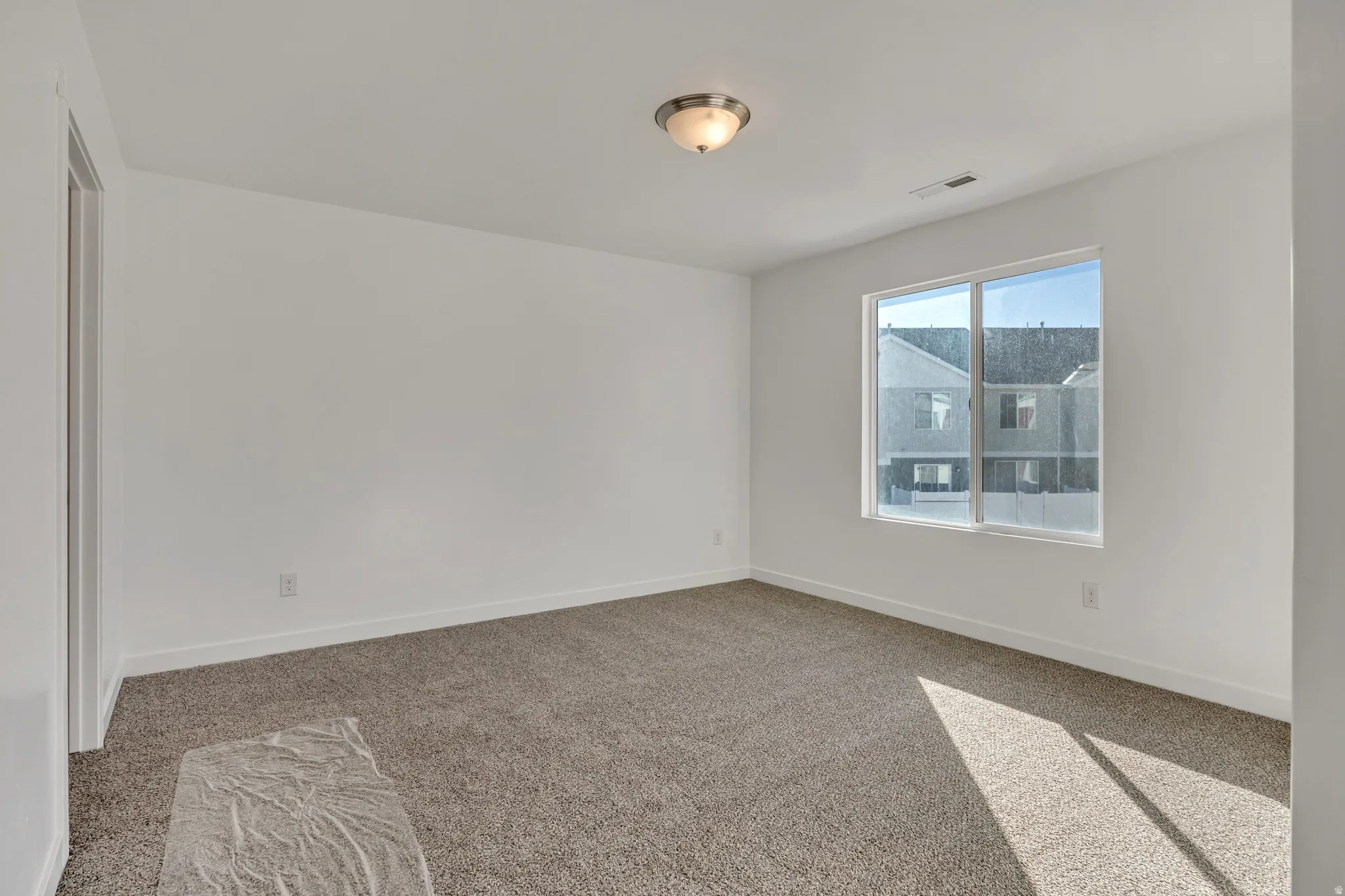Unfurnished room featuring light colored carpet and baseboards