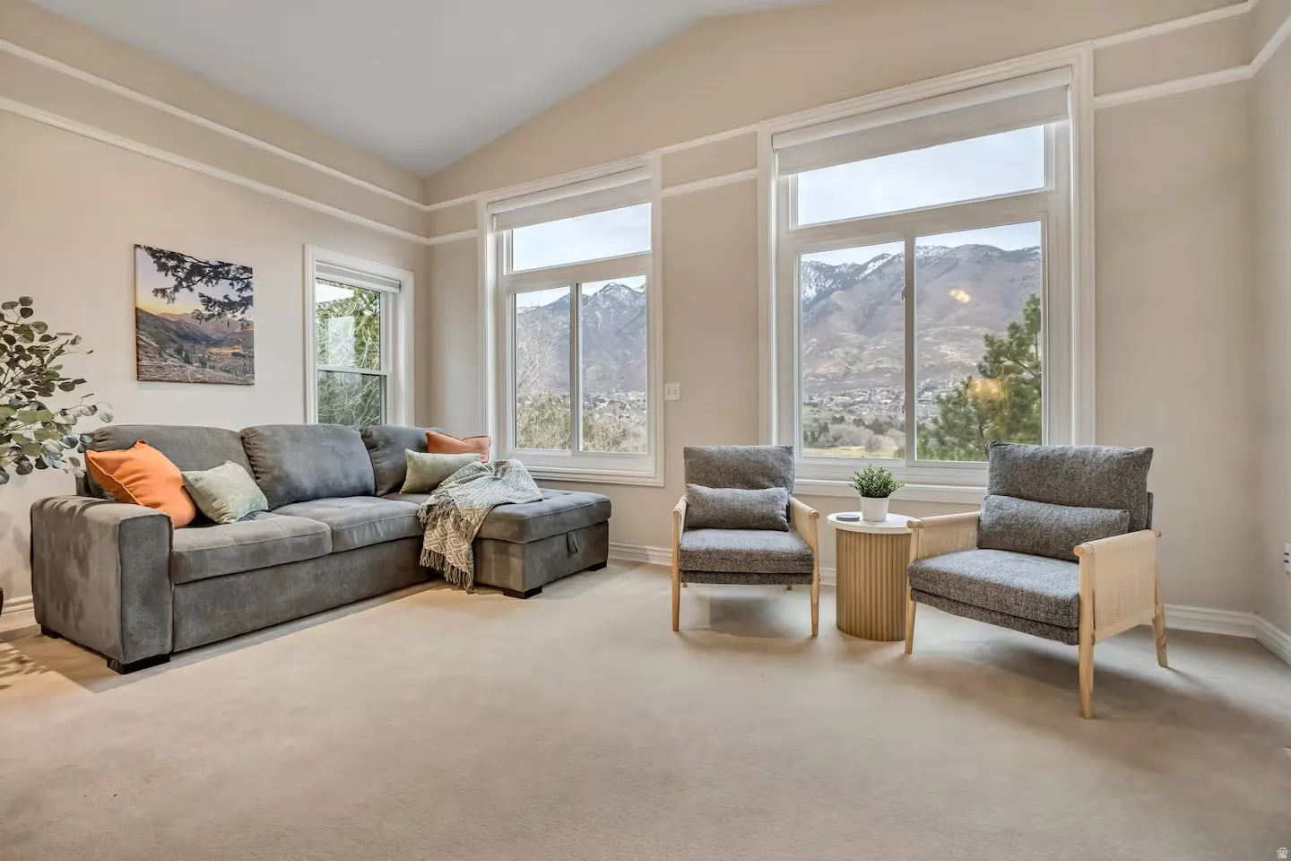 Living area with a mountain view, light carpet, and vaulted ceiling