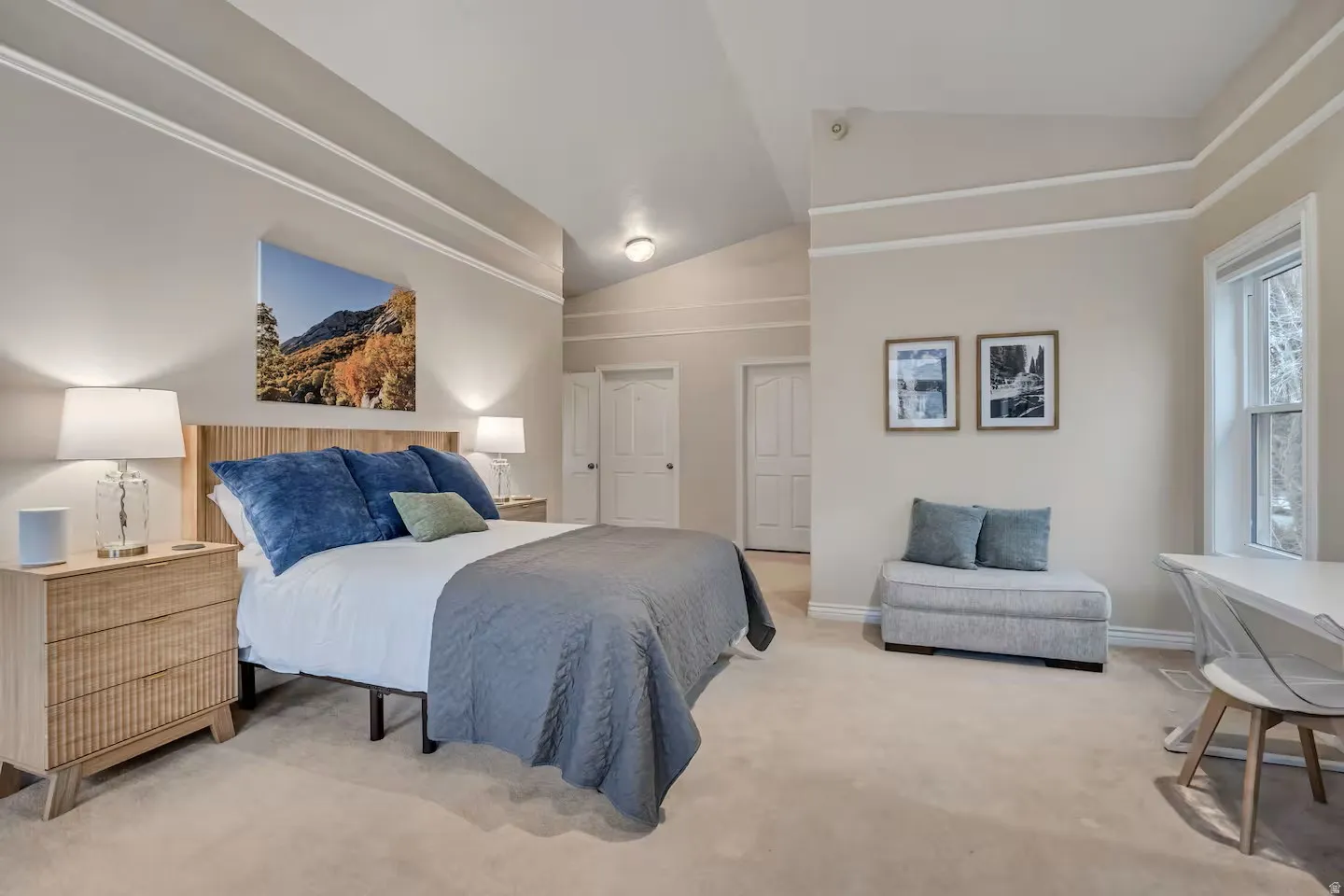 Bedroom featuring vaulted ceiling, multiple closets, and light carpet