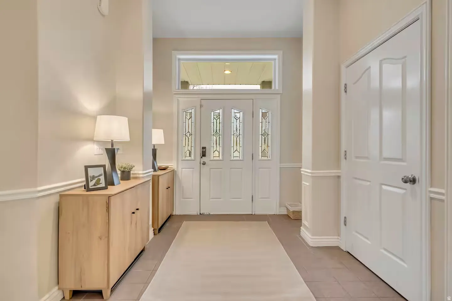Foyer with light tile patterned floors and baseboards